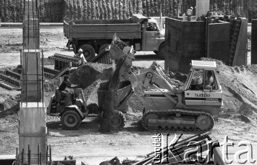 26.05.1979, Warszawa, Polska.
Budowa wieżowca LOT- u. Robotnicy pracują przy użyciu maszyn budowlanych - załadunek piachu.
Fot. Jarosław Tarań, zbiory Ośrodka KARTA [79-17]