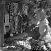 Sierpień 1979, Wysokie Mazowieckie, woj. łomżyńskie, Polska.
Kobieta z dzieckiem przy straganie z odpustowymi zabawkami i biżuterią.
Fot. Jarosław Tarań, zbiory Ośrodka KARTA [79-6] 
