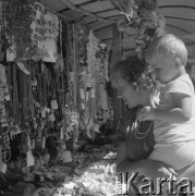 Sierpień 1979, Wysokie Mazowieckie, woj. łomżyńskie, Polska.
Kobieta z dzieckiem przy straganie z odpustowymi zabawkami i biżuterią.
Fot. Jarosław Tarań, zbiory Ośrodka KARTA [79-6]