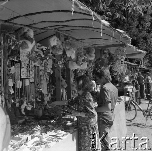 Sierpień 1979, Wysokie Mazowieckie, woj. łomżyńskie, Polska.
Kobieta i chłopiec przy straganie z odpustowymi zabawkami i biżuterią. Na drugim planie widoczny jest rower.
Fot. Jarosław Tarań, zbiory Ośrodka KARTA [79-6]