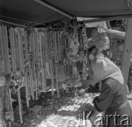 Sierpień 1979, Wysokie Mazowieckie, woj. łomżyńskie, Polska.
Kobieta w chustce przy straganie z odpustowymi zabawkami i biżuterią.
Fot. Jarosław Tarań, zbiory Ośrodka KARTA [79-6]