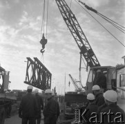 29.09.1979, Warszawa, Polska.
Budowa wiaduktu Trasy Toruńskiej - dźwigi transportujące elementy konstrukcyjne na miejsce budowy. Na pierwszym planie widoczni są robotnicy.
Fot. Jarosław Tarań, zbiory Ośrodka KARTA [79-3]