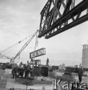 29.09.1979, Warszawa, Polska.
Budowa wiaduktu Trasy Toruńskiej - dźwigi transportujące elementy konstrukcyjne na miejsce budowy. Widoczni są również robotnicy.
Fot. Jarosław Tarań, zbiory Ośrodka KARTA [79-3]