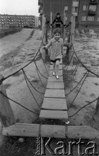 13.10.1979, Gorzów Wielkopolski, woj. gorzowskie, Polska.
Osiedle mieszkaniowe - plac zabaw. Dzieci przebiegają przez wiszący mostek. W oddali widoczne są bloki mieszkalne oraz wóz z koniem.
Fot. Jarosław Tarań, zbiory Ośrodka KARTA [79-57] 
