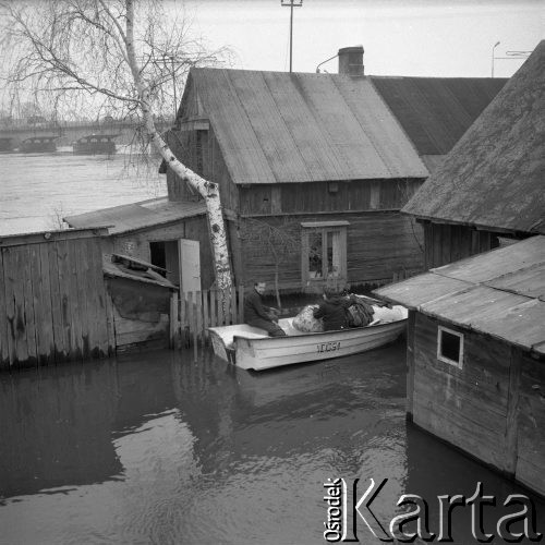 Marzec 1979, Wyszków okolice, woj. Ostrołęka, Polska.
Ewakuacja ludności z terenów objętych powodzią - kobieta i mężczyzna opuszczają podtopione domostwo. W oddali widoczny jest most na rzece Bug.
Fot. Jarosław Tarań, zbiory Ośrodka KARTA [79-24]