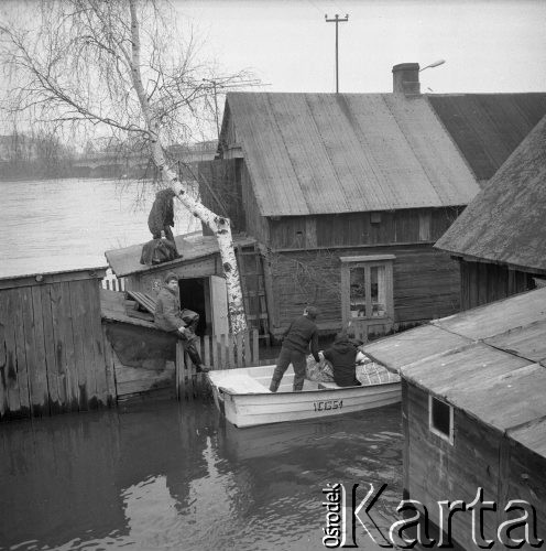 Marzec 1979, Wyszków okolice, woj. Ostrołęka, Polska.
Ewakuacja ludności z terenów objętych powodzią. Kobieta i mężczyzna opuszczają podtopione domostwo. W oddali widoczny jest most na rzece Bug.
Fot. Jarosław Tarań, zbiory Ośrodka KARTA [79-24]