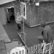 Marzec 1979, Wyszków okolice, woj. Ostrołęka, Polska.
Powódź - mieszkańcy podtopionego domu. Na pierwszym planie widoczny jest mężczyzna siedzący na płocie.
Fot. Jarosław Tarań, zbiory Ośrodka KARTA [79-23] 
