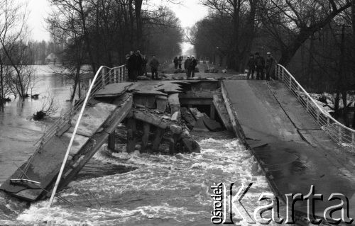 Marzec 1979, Brok okolice, woj. Ostrołęka, Polska.
Powódź w rejonie Broku - mieszkańcy miejscowości oglądają zerwany most na Bugu. W oddali widoczne są podtopione drzewa oraz łąki. 
Fot. Jarosław Tarań, zbiory Ośrodka KARTA [79-27] 
