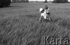 Czerwiec 1981, Zagozd, pow. Drawsko Pomorskie, Polska
Gospodarstwo rodziny Grzybickich, mężczyzna z chłopcem na polu zboża.
Fot. Jarosław Tarań, zbiory Ośrodka KARTA [81-31]