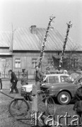 12.04.1981, Łyse, woj. Ostrołęka, Polska
Niedziela Palmowa na Kurpiach, wierni z palmami na parkingu między samochodami, na pierwszym planie rower.
Fot. Jarosław Tarań, zbiory Ośrodka KARTA [81-12] 
