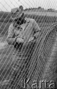 4-5.06.1981, Pelnik, woj. Olsztyn, Polska
Rybak z Zespołu Rybackiego Ostróda naprawiający sieć.
Fot. Jarosław Tarań, zbiory Ośrodka KARTA [81-45] 
