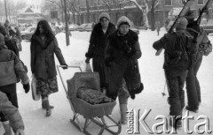 18-20.02.1985, Zakopane, Polska
Ośnieżona ulica, kobieta z dziecięcym wózkiem z płozami sanek w miejsce kółek, z prawej dwie osoby z nartami.
Fot. Jarosław Tarań, zbiory Ośrodka KARTA [85-36] 
