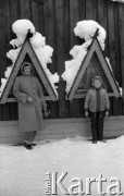 18-20.02.1985, Zakopane, Polska
Kobieta i chłopiec na ulicy pod ośnieżonymi drewnianymi daszkami.
Fot. Jarosław Tarań, zbiory Ośrodka KARTA [85-35] 
