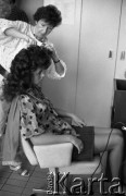 Maj 1985, Warszawa, Polska.
Wybory Miss Polonia, wizyta w zakładzie fryzjerskim, dziewczyna siedząca na fotelu, obok stoi czesząca ją fryzjerka.
Fot. Jarosław Tarań, zbiory Ośrodka KARTA [85-15]