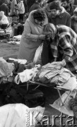 22.11.1986, Warszawa - Rembertów, Polska.
Bazar z ubraniami w Rembertowie, kobiety oglądające konfekcję leżącą na polowym łóżku.
Fot. Jarosław Tarań, zbiory Ośrodka KARTA, [86-43] 
