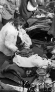 22.11.1986, Warszawa - Rembertów, Polska.
Bazar w Rembertowie, kobieta oglądająca ubrania.
Fot. Jarosław Tarań, zbiory Ośrodka KARTA, [86-43] 
