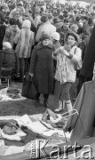 22.11.1986, Warszawa - Rembertów, Polska.
Bazar z ubraniami w Rembertowie, kobieta oglądająca bluzkę w kwiaty.
Fot. Jarosław Tarań, zbiory Ośrodka KARTA, [86-43] 
