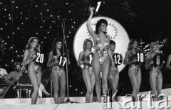 2.08.1986, Sopot, Polska.
Opera Leśna, finał wyborów Miss Polonia, dziewczyny w kostiumach kąpielowych, na pierwszym planie Małgorzata Szalacha, z tyłu od lewej stoją: Renata Fatla, (przyszła Miss Polonia), Beata Smela (Miss Publiczności), NN, Anna Tilmann (III Vice Miss), Joanna Borsukiewicz i Violetta Tomasik.
Fot. Jarosław Tarań, zbiory Ośrodka KARTA, [86-14]