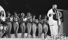2.08.1986, Sopot, Polska.
Opera Leśna, finał wyborów Miss Polonia, dziewczyny w strojach kąpielowych, stoją od lewej: Joanna Sitkowska, Anna Tilmann, Dorota Umańska, Joanna Baranowska, Maria Wadecka, Małgorzata Szczygielska, Beata Smela, Wiesława Sicińska, przy mikrofonie stoi - Tadeusz Drozda.
Fot. Jarosław Tarań, zbiory Ośrodka KARTA, [86-18] 
