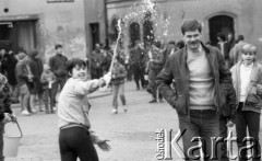 1987, Warszawa, Polska.
Lany poniedziałek na Rynku Starego Miasta, chłopiec oblewający wodą przechodnia.
Fot. Jarosław Tarań, zbiory Ośrodka KARTA [87-58] 
