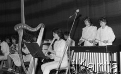11.04.1987, Warszawa, Polska.
Koncert Żoliborskiej Orkiestry Dziecięco-Młodzieżowej, dziewczyna grająca na flecie prostym, z lewej stoi harfa, z prawej dziewczyny grające na ksylofonie.
Fot. Jarosław Tarań, zbiory Ośrodka KARTA [87-84] 
