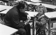 27.06.1987, Warszawa, Polska.
Aula Politechniki Warszawskiej, sesja fotograficzna finalistek konkursu Miss Polonia do kalendarza na rok 1988, mężczyzna z odtwarzaczem CD i dziecko.
Fot. Jarosław Tarań, zbiory Ośrodka KARTA [87-2] 
