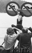 18.07.1987, Wieżyca, Polska
Wybory Miss Polonia, plener fotograficzny, dziewczyna pozująca na tle znaków zakazujących skoków do wody i pływania.
Fot. Jarosław Tarań, zbiory Ośrodka KARTA [87-20] 
