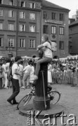 1988, Warszawa, Polska.
Rynek Starego Miasta, koncert orkiestry symfonicznej ze Stanów Zjednoczonych, długowłosy chłopak z plecakiem siedzący na studni.
Fot. Jarosław Tarań, zbiory Ośrodka KARTA [88-52] 
