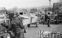 Marzec 1989, Nowy Targ, Polska
Czwartkowy targ w Nowym Targu, traktory z przyczepami na parkingu, w tle dachy domów i góry.
Fot. Jarosław Tarań, zbiory Ośrodka KARTA [89-59] 
