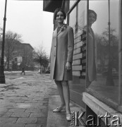 28.02.1968, Warszawa, Polska.
Pokaz mody - modelka w płaszczu na tle witryny sklepowej.
Fot. Jarosław Tarań, zbiory Ośrodka KARTA
