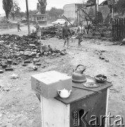 11.07.1968, Lubowidz, woj. mazowieckie, Polska.
Pogorzelisko -  sprzęty kuchenne, kobiety niosące wiadro wody.
Fot. Jarosław Tarań, zbiory Ośrodka KARTA