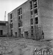 23.08.1968, Bzie Zameckie k./Jastrzębia-Zdroju, woj. katowickie, Polska
Budowa Fabryki Domów - zakładu produkującego płyty oraz elementy przestrzenne wykorzystywane przy budowie nowoczesnych bloków mieszkalnych. Robotnicy niosą żelazną konstrukcję, na dalszym planie mężczyźni pracują nad wykończeniem otworów okiennych. 
Fot. Jarosław Tarań, zbiory Ośrodka KARTA