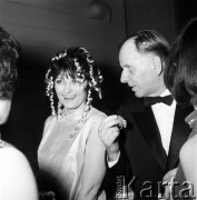 1.01.1968, Warszawa, Polska.
Bal Sylwestrowy. Karykaturzysta, satyryk i dziennikarz Eryk Lipiński rozmawia z kobietą, której fryzurę zdobią złote serpentyny.   
Fot. Jarosław Tarań, zbiory Ośrodka KARTA