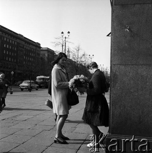 25.04.1968, Warszawa, Polska.
Plac Konstytucji - kwiaciarka sprzedająca bukiet kwiatów młodej kobiecie. Na drugim planie widoczne są przejeżdżające samochody oraz budynki Marszałkowskiej Dzielnicy Mieszkaniowej. 
Fot. Jarosław Tarań, zbiory Ośrodka KARTA