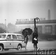 25.08.1968, Warszawa - Śródmieście, Polska.
Ulewa w Warszawie. Kobiety czekające na przystanku tramwajowym. W tle dworzec kolejowy Warszawa Śródmieście, z prawej karetka Pogotowia Ratunkowego.
Fot. Jarosław Tarań, zbiory Ośrodka KARTA