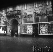 25.08.1968, Warszawa - Śródmieście, Polska.
 Aleje Jerozolimskie 61. Ludzie chroniący się w bramie kamienicy przed deszczem, z prawej witryna Domu Książki.
Fot. Jarosław Tarań, zbiory Ośrodka KARTA