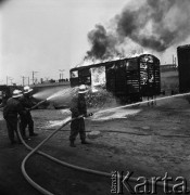 Październik 1968, Warszawa, Polska. 
Ćwiczenia samoobrony na Dworcu Wschodnim. Strażacy gaszący pianą płonący wagon, w tle podróżni na peronie obserwujący akcję. 
Fot. Jarosław Tarań, zbiory Ośrodka KARTA