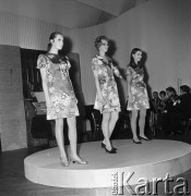 26.02.1968, Warszawa, Polska.
Pokaz setnej kolekcji firmy CORA zaprojektowanej przez Jadwigę Grabowską. Trzy modelki w krótkich sukienkach w kwiaty, w tle akompaniatorzy.
Fot. Jarosław Tarań, zbiory Ośrodka KARTA