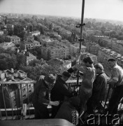 1968, Warszawa, Polska.
Robotnicy montujący zegar na dachu wieżowca przy Rondzie Waszyngtona. 
Fot. Jarosław Tarań, zbiory Ośrodka KARTA