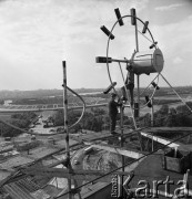 1968, Warszawa, Polska.
Robotnicy montujący zegar na dachu wieżowca przy Rondzie Waszyngtona, w tle Stadion X-o Lecia. 
Fot. Jarosław Tarań, zbiory Ośrodka KARTA