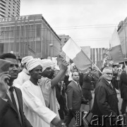 01.05.1968, Warszawa, Polska.
Pochód pierwszomajowy w centrum Warszawy. Delegacja Sudańczyków w białych szatach i turbanach. Obok manifestanci z polskimi flagami, w tle Domy Towarowe 