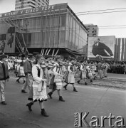 01.05.1968, Warszawa, Polska.
Pochód pierwszomajowy w centrum Warszawy. Na pierwszym planie młodzież w strojach ludowych grająca na skrzypcach, w tle Domy Towarowe 