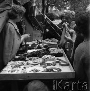 1968, Warszawa, Polska.
Festyn dziecięcy w parku Skaryszewskim. Stragan z odzieżą i dodatkami, wokół klientki oglądające towar.
Fot. Jarosław Tarań, zbiory Ośrodka KARTA