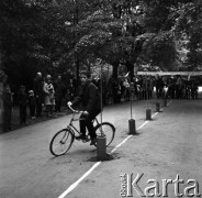 1968, Warszawa, Polska.
Festyn dziecięcy w parku Skaryszewskim. Chłopiec na rowerze podczas jazdy slalomem, w tle tłum kibiców dopingujący uczestników zawodów.
Fot. Jarosław Tarań, zbiory Ośrodka KARTA