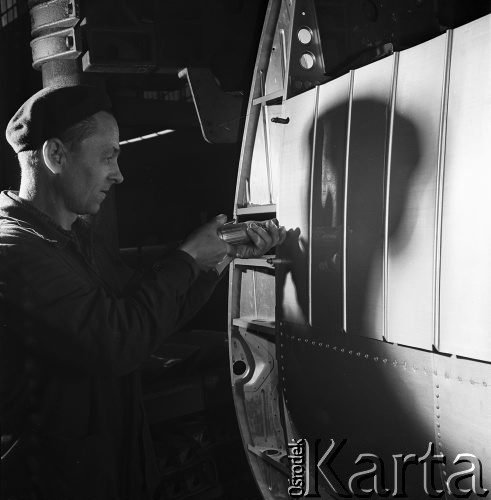 1968, Warszawa, Polska.
Wytwórnia Sprzętu Komunikacyjnego WSK-Okęcie. Mechanik przy produkcji samolotu.
Fot. Jarosław Tarań, zbiory Ośrodka KARTA