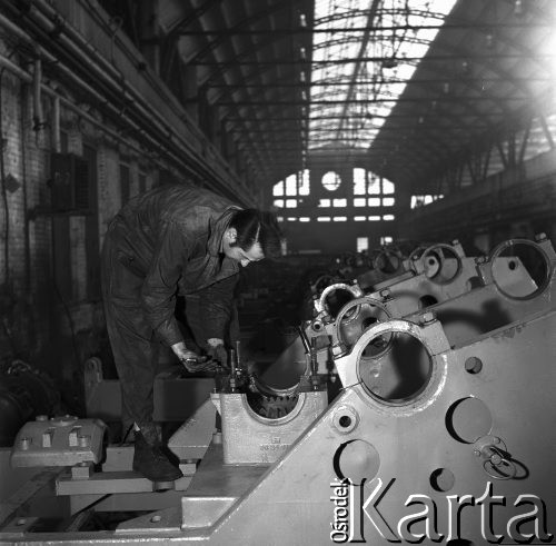 1968, Warszawa, Polska.
Warszawskie Zakłady Maszyn Budowlanych im. Ludwika Waryńskiego. Mechanik w hali produkcyjnej przy pracy.
Fot. Jarosław Tarań, zbiory Ośrodka KARTA