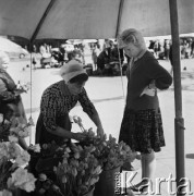 1968, Kraków, Polska.
Rynek Główny w Krakowie. Kobieta kupująca tulipany u krakowskiej handlarki, w tle stojące stragany z kwiatami.
Fot. Jarosław Tarań, zbiory Ośrodka KARTA