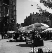 1968, Kraków, Polska.
Rynek Główny w Krakowie. Stragany z kwiatami stojące na rynku, w tle Kościół Mariacki i zabytkowa kamienica.
Fot. Jarosław Tarań, zbiory Ośrodka KARTA