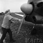 1968, Polska.
Ogólnopolski Rajd Samolotowy. Mężczyzna sprawdzających sprawność śmigła w samolocie.
Fot. Jarosław Tarań, zbiory Ośrodka KARTA