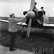1968, Polska.
Ogólnopolski Rajd Samolotowy. Dwóch lotników siedzących w kadłubie samolotu oraz mążczyzna sprawdzający śmigło.
Fot. Jarosław Tarań, zbiory Ośrodka KARTA